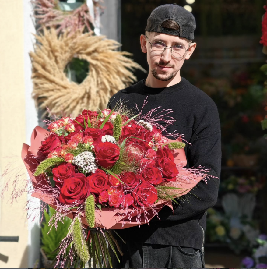 Właściciel Pan Kwiatowy z bukietem czerwonych róż